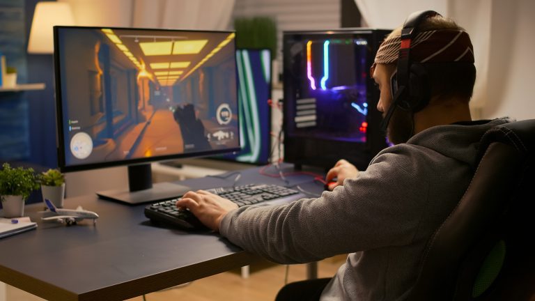 Video game designer wearing headphones playing a game